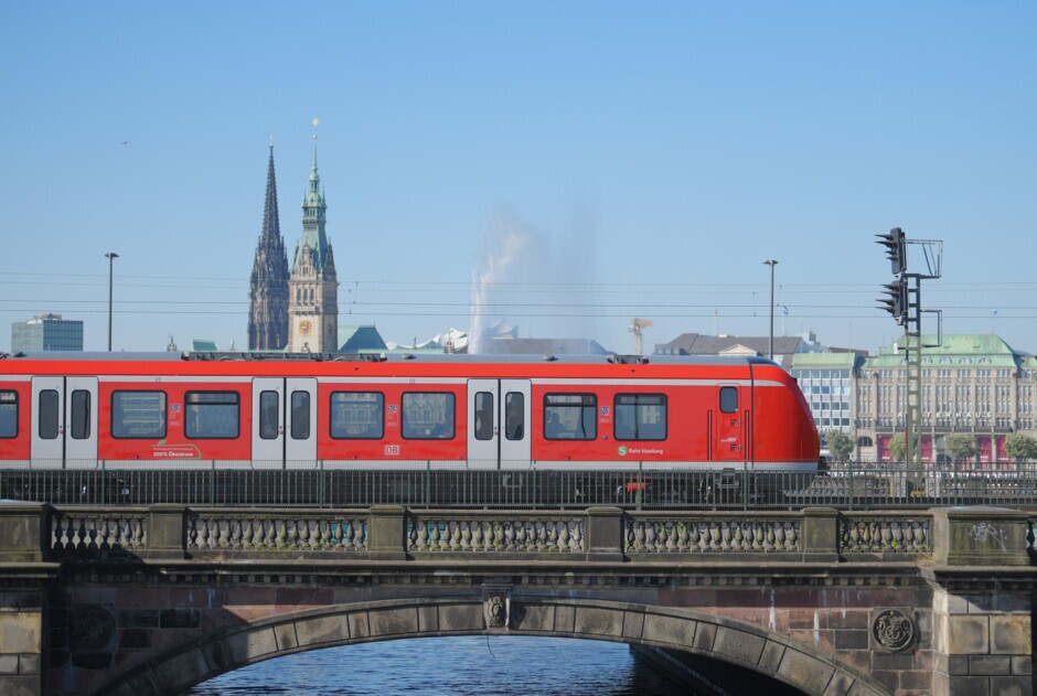S-Bahn auf der Lombardsbrücke in Hamburg mit Rathaus und Mahnmal St. Nikolai im Hintergrund